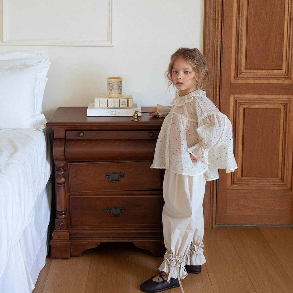 Child wearing NOU NOU Spring Smocked Waist Pants in Light Beige