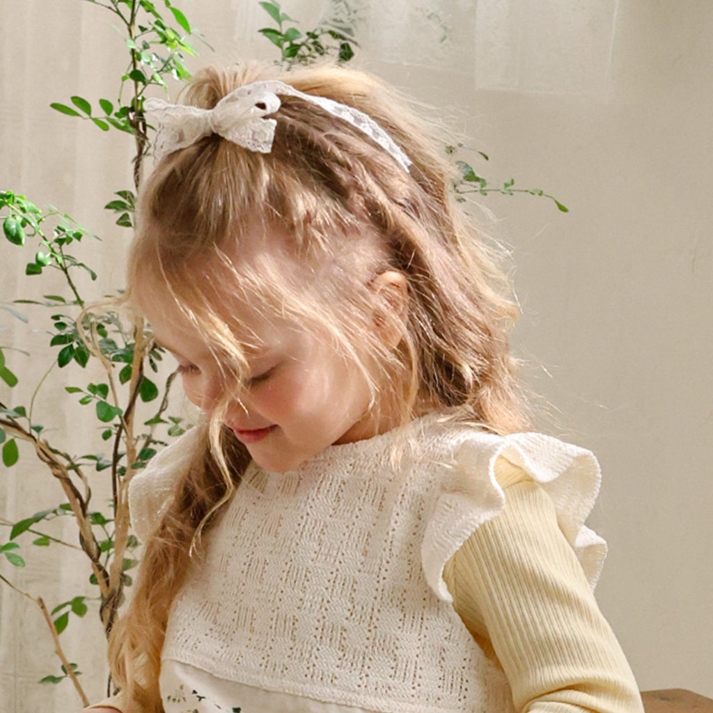 Child wearing Puella Flo Mitchell Lace Bow Hair Clip in Ivory